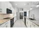 Galley kitchen with stainless steel appliances, granite countertops and white cabinetry at 3048 Borassus Dr, New Smyrna Beach, FL 32168