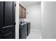 Laundry room features modern washer and dryer, dark cabinets, and neutral paint at 3048 Borassus Dr, New Smyrna Beach, FL 32168