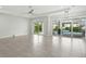 Bright living room with tiled floor, ceiling fan and sliding glass doors leading to the pool area at 3048 Borassus Dr, New Smyrna Beach, FL 32168