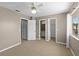 Bedroom featuring carpeted floors, a ceiling fan, and multiple doors leading to the bathroom and closets at 3522 Forest Branch Dr # D, Port Orange, FL 32129