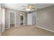 Bedroom with carpet, ceiling fan, and doors to closet and bathroom, offering comfort and convenience at 3522 Forest Branch Dr # D, Port Orange, FL 32129