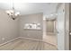 Open dining room with a chandelier and a view to the kitchen, featuring light-colored walls and flooring at 3522 Forest Branch Dr # D, Port Orange, FL 32129