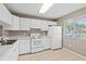 Bright kitchen features white cabinetry and appliances with a window at 3522 Forest Branch Dr # D, Port Orange, FL 32129