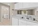 Bright kitchen featuring white cabinets, stainless steel sink, and view to an adjacent room and back yard at 3522 Forest Branch Dr # D, Port Orange, FL 32129