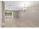 Spacious living room with light wood flooring, a ceiling fan, chandelier and sliding glass doors to the lanai at 3522 Forest Branch Dr # D, Port Orange, FL 32129