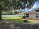 Spacious backyard with lush green grass, mature trees, white fence, and fire pit at 465 Dahoon Holly Dr, Daytona Beach, FL 32117