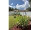 Landscaped backyard featuring a swing set, lush greenery, mulch, and a well-maintained lawn at 465 Dahoon Holly Dr, Daytona Beach, FL 32117