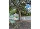 Backyard featuring a shed and a mature tree, enclosed by a white picket fence for privacy and charm at 465 Dahoon Holly Dr, Daytona Beach, FL 32117