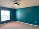 Bedroom with blue accent wall, neutral carpet and fan, with a window for lots of light at 465 Dahoon Holly Dr, Daytona Beach, FL 32117