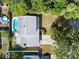 Aerial perspective of a home with a private pool and well-maintained backyard, nestled amongst mature trees at 506 Dorset Cir, South Daytona, FL 32119