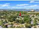 Sprawling aerial shot of a neighborhood featuring mature trees and a distant cityscape view on the horizon at 506 Dorset Cir, South Daytona, FL 32119