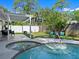 Backyard view of covered patio, kidney-shaped pool, and a white privacy fence at 506 Dorset Cir, South Daytona, FL 32119