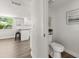 Half bathroom with modern toilet, vanity, and hardwood floors adjacent to kitchen at 506 Dorset Cir, South Daytona, FL 32119
