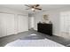Bedroom with a ceiling fan, neutral carpet, and white closets at 506 Dorset Cir, South Daytona, FL 32119