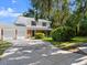 Inviting two-story home with a spacious driveway and well-manicured lawn surrounded by lush greenery at 506 Dorset Cir, South Daytona, FL 32119