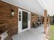 Cozy front porch with brick siding, decorative lighting, and comfortable seating, creating a welcoming entrance at 506 Dorset Cir, South Daytona, FL 32119