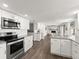 Modern kitchen with white cabinets, granite countertops, stainless steel appliances, and open layout at 506 Dorset Cir, South Daytona, FL 32119