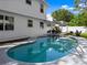Backyard pool with clean, clear water and a partial view of the white two-story house at 506 Dorset Cir, South Daytona, FL 32119