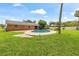 Large backyard with a pool, brick house, and well-maintained lawn for outdoor enjoyment at 950 Pineapple Rd, South Daytona, FL 32119