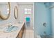 Bathroom featuring a tub with blue tiles, shower, dual sinks, and a decorative mirror at 950 Pineapple Rd, South Daytona, FL 32119