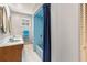 Bathroom featuring a tub, shower, blue tile, dual sinks, and a decorative mirror at 950 Pineapple Rd, South Daytona, FL 32119