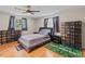 Well-lit bedroom features hardwood floors, fan, and a king-size bed with two bedside tables at 950 Pineapple Rd, South Daytona, FL 32119