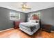 Bedroom with hardwood floors, ceiling fan, dresser, and bed with gray comforter at 950 Pineapple Rd, South Daytona, FL 32119