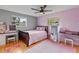 Bedroom features hardwood floors, ceiling fan, writing desks, a window and bed with pink comforter at 950 Pineapple Rd, South Daytona, FL 32119