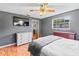 Bedroom with grey walls, ceiling fan, hardwood floors, mounted television, and bed at 950 Pineapple Rd, South Daytona, FL 32119