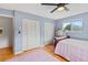 Bedroom with pink rug, hardwood floors, ceiling fan, two closets, and a window at 950 Pineapple Rd, South Daytona, FL 32119