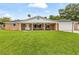 Charming red brick home with a covered front porch and a large, well-manicured lawn at 950 Pineapple Rd, South Daytona, FL 32119