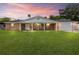 Charming brick home featuring a manicured lawn and covered porch perfect for enjoying sunset views at 950 Pineapple Rd, South Daytona, FL 32119