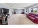 Spacious living room featuring plush carpeting, a large window, and a comfortable red leather sofa at 950 Pineapple Rd, South Daytona, FL 32119