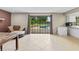 Open living space with couch, tile floors, large window overlooking pool, and a partial kitchen view at 950 Pineapple Rd, South Daytona, FL 32119