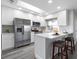 Bright kitchen featuring white cabinetry, stainless steel appliances, gray countertops and barstool seating at 105 Bonita Pl, Ormond Beach, FL 32174