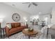 Inviting living room features a leather sofa, ceiling fan, and an open layout into the kitchen at 105 Bonita Pl, Ormond Beach, FL 32174