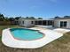 Inviting kidney-shaped pool with brick trim and concrete patio, perfect for outdoor relaxation and entertaining at 105 Bonita Pl, Ormond Beach, FL 32174