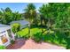 Green backyard with patio, firepit, chairs and lush tropical landscaping at 1221 Gamble Pl, Daytona Beach, FL 32118
