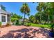 Brick patio and backyard with mature trees and tropical landscaping at 1221 Gamble Pl, Daytona Beach, FL 32118