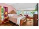 Bedroom with original hardwood floors, vintage furniture, and sunroom overlooking the yard at 1221 Gamble Pl, Daytona Beach, FL 32118