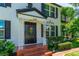 Close-up of the front entrance with decorative door frame, brick steps, and manicured landscaping at 1221 Gamble Pl, Daytona Beach, FL 32118