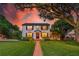 Beautiful two-story home with lush lawn and brick walkway leading to the entrance, illuminated by a vibrant sunset at 1221 Gamble Pl, Daytona Beach, FL 32118