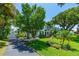 Charming two-story home with manicured lawn, mature landscaping, and a long driveway leading to a detached garage at 1221 Gamble Pl, Daytona Beach, FL 32118