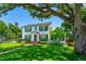 Charming two-story home featuring a well-manicured lawn, mature trees, and an inviting brick walkway to the front door at 1221 Gamble Pl, Daytona Beach, FL 32118
