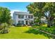 Elegant two-story home with manicured lawn and a brick walkway leading to the front door, framed by lush landscaping at 1221 Gamble Pl, Daytona Beach, FL 32118