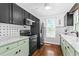 Updated kitchen with black and green cabinets, marble countertops, and modern appliances at 1221 Gamble Pl, Daytona Beach, FL 32118