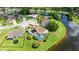 Aerial view of home with screened pool area overlooking a lake in a lush green setting at 1904 Rouzbeh Ct, Port Orange, FL 32128