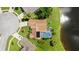 Aerial view of home featuring screened-in pool and lake view in lush green setting at 1904 Rouzbeh Ct, Port Orange, FL 32128