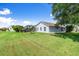 Spacious backyard with a well-maintained lawn, mature trees, and a screened patio at 1904 Rouzbeh Ct, Port Orange, FL 32128