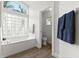 Bright bathroom with a garden tub, tile floors, and a large window for natural light at 1904 Rouzbeh Ct, Port Orange, FL 32128